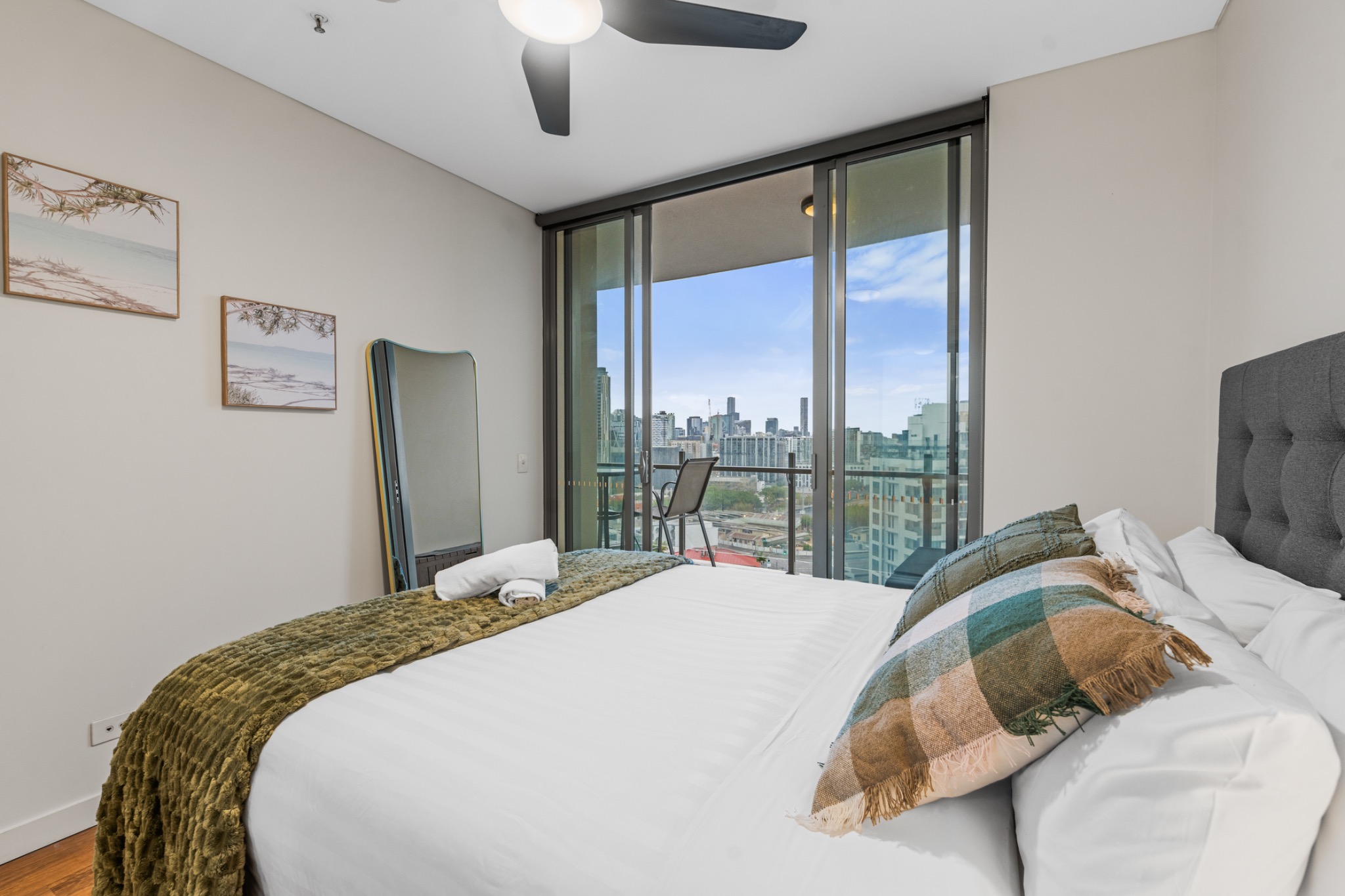 Bedroom with layered bedding and balcony